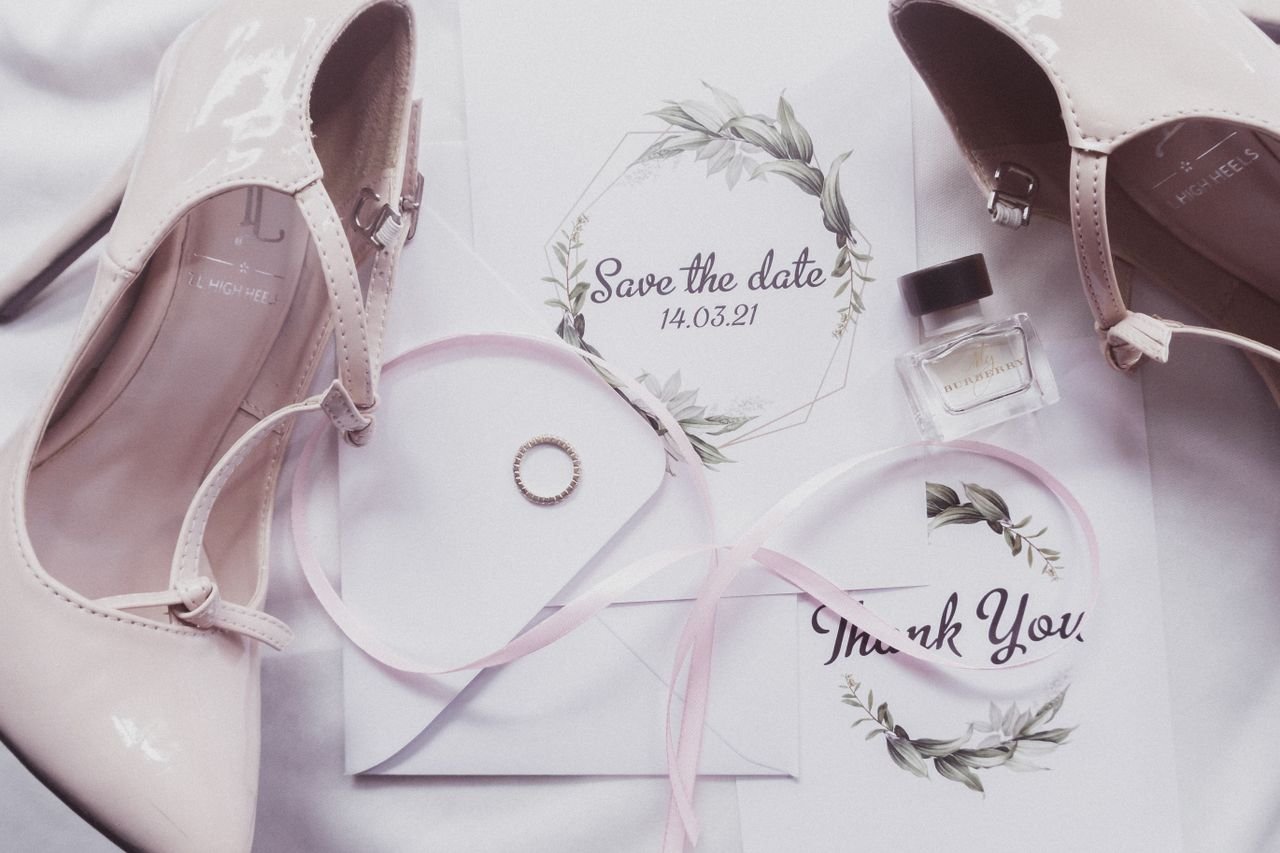 about-02 A chic flat lay of wedding essentials including heels, perfume, and invitations.